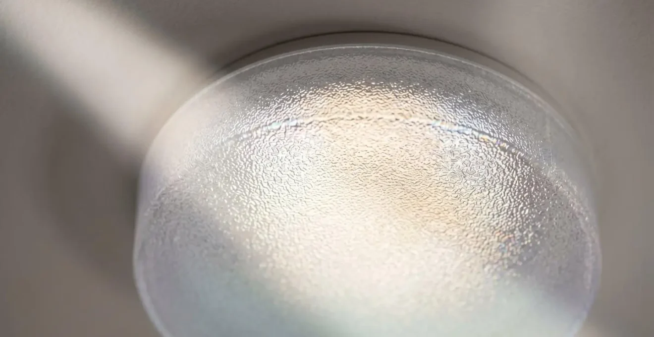 Détail macro d'un diffuseur de conduit de lumière naturelle installé au plafond avec rayons lumineux